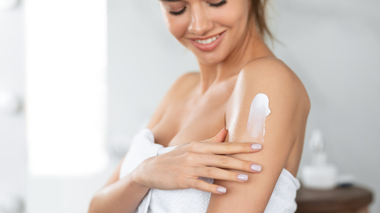 Woman applying moisturizer