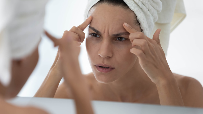 Woman scrutinizing her face 