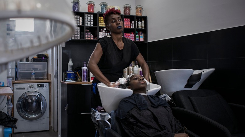 Hairstylist washing woman's hair