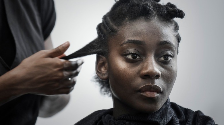young woman having hair twisted