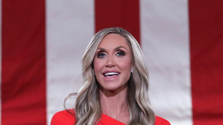 Lara Trump smiles in front of an American flag