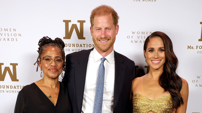 Prince Harry and Meghan Markle pose with Meghan's mother