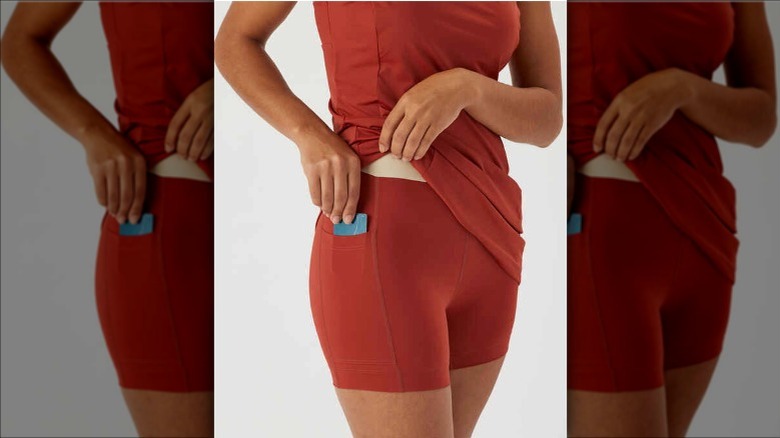 Woman putting phone in her swim dress pocket