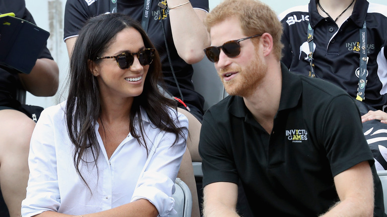 Prince Harry and Meghan Markle talking during game