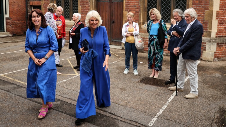 Queen Camilla walking in bright blue jumpsuit 