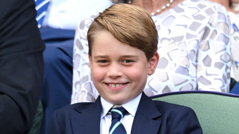 Prince George smiling while watching tennis