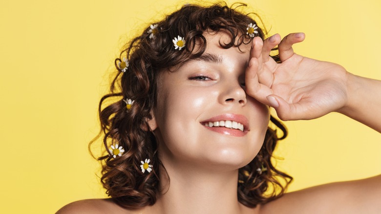 woman smiling with daisies in hair