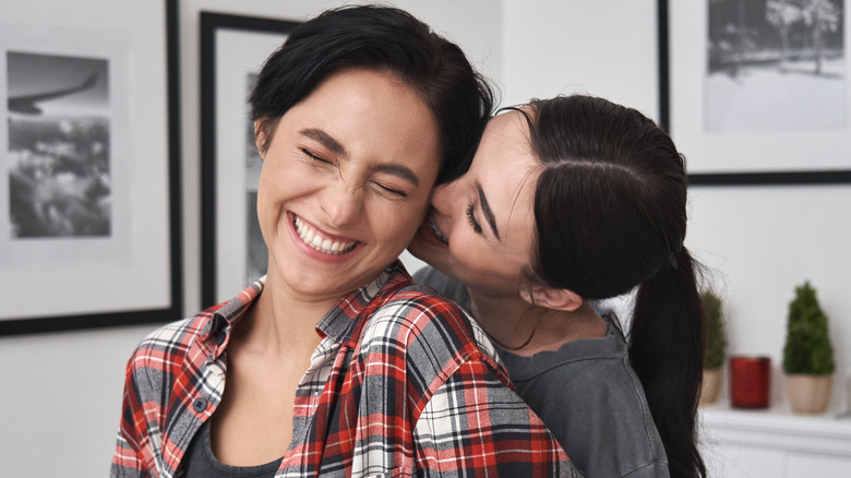 two women smiling and kissing