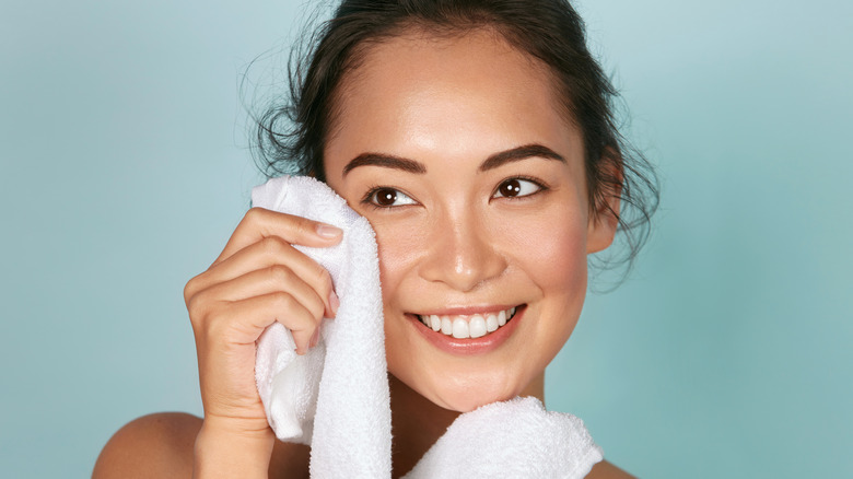 woman wiping her face with a towel 