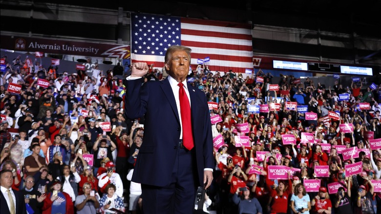 Donald Trump holds his fist up in the air at an event