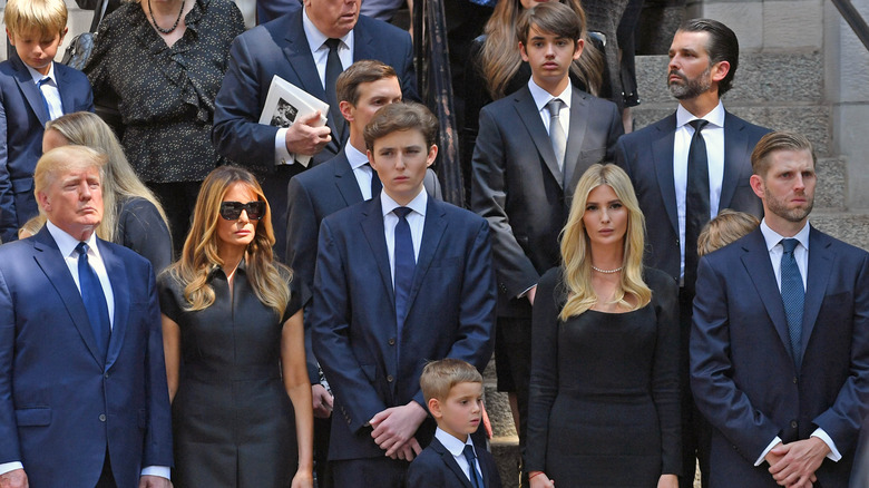 Donald Trump and family stand on the stairs