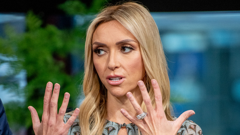 A serious Giuliana Rancic holding up her hands