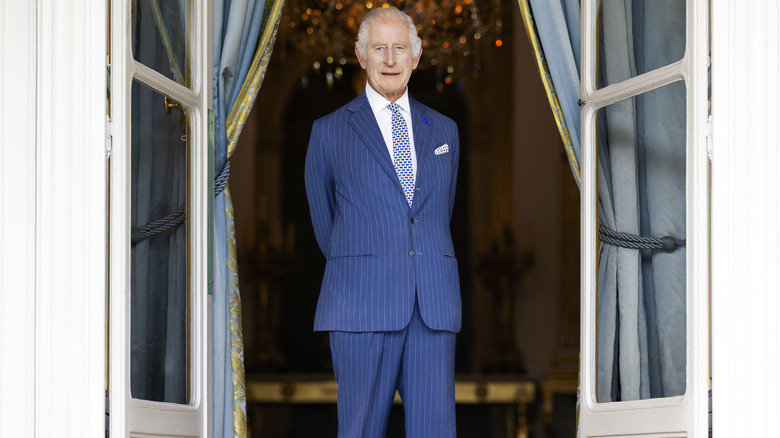 King Charles III standing at window