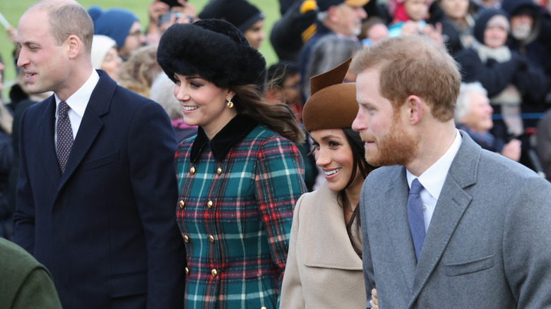 Prince Harry and Prince William walking together with their wives