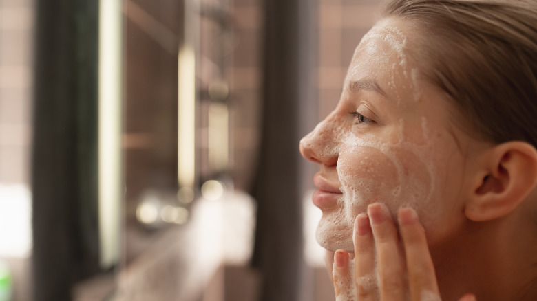 Woman applying a cleanser on her face