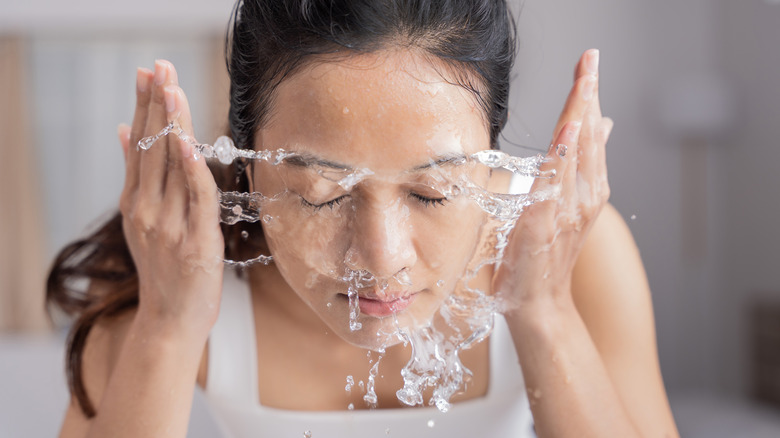 woman splashing water on her face