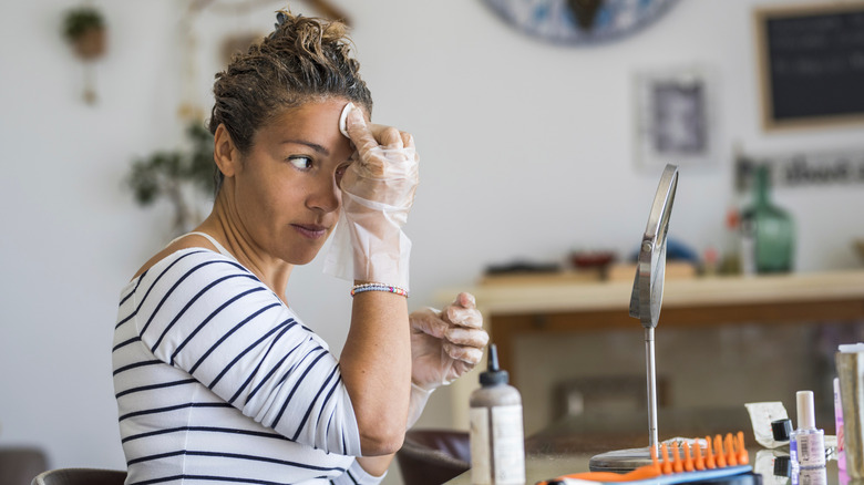 A woman removing hair dye stains from her head