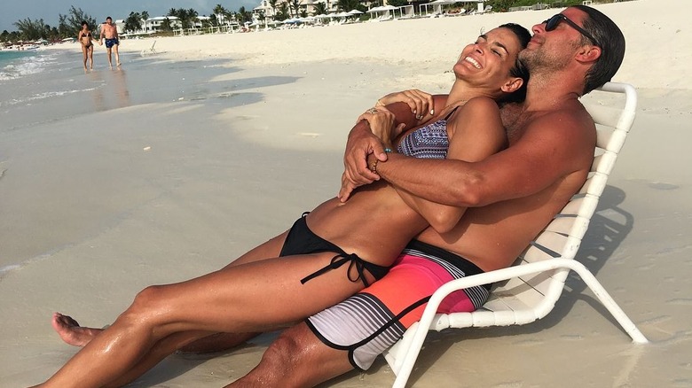 Angie Harmon and Greg Vaughn laying together on beach