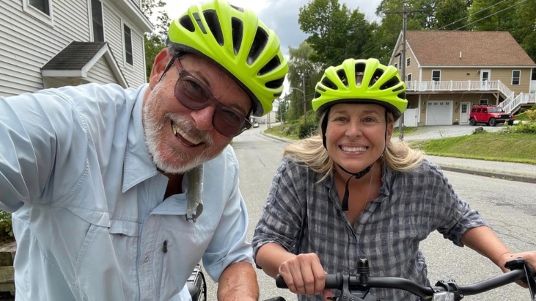 Jonathan Frakes and Genie Francis smiling in green biking helmets