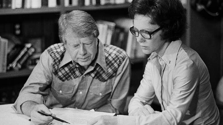 Jimmy and Rosalynn Carter reading papers together