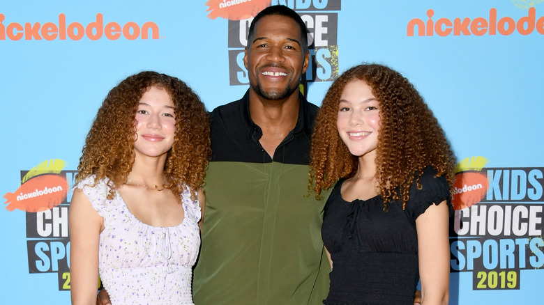 Michael Strahan smiling with his daughters