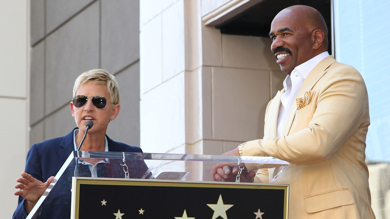 Steve Harvey smiling next to Ellen DeGeneres