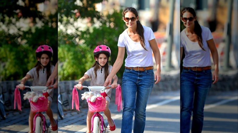 Suri Cruise riding a pink bicycle with mom Katie Holmes