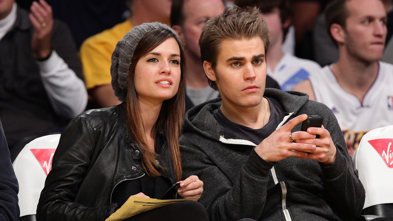 Torrey DeVitto and Paul Wesley at a basketball game