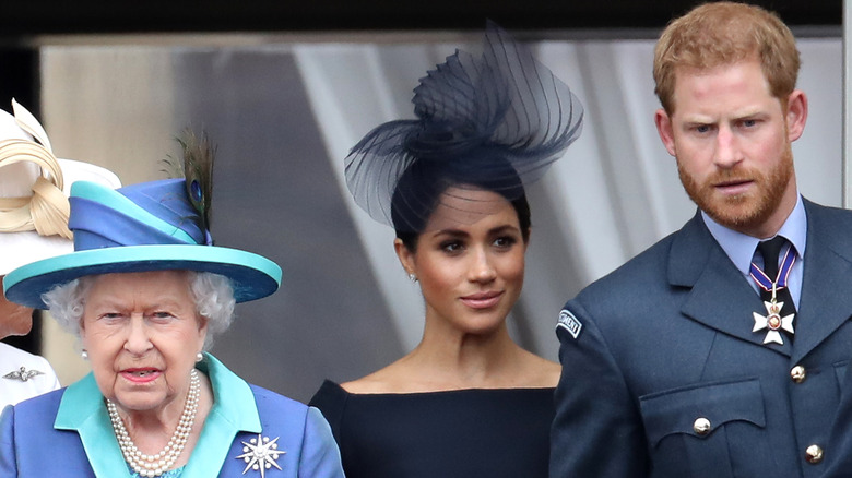 Queen Elizabeth II, Prince Harry, Duke of Sussex and Meghan, Duchess of Sussex on the balcony of Buckingham Palace as the Royal family attend events to mark the Centenary of the RAF in London (2018)