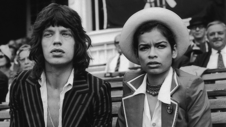 Mick Jagger sits alongside his wife Bianca