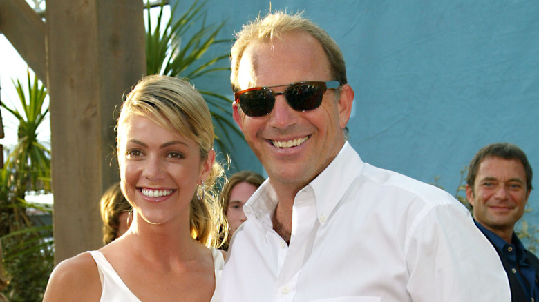 Kevin Costner smiling with Christine Baumgartner.