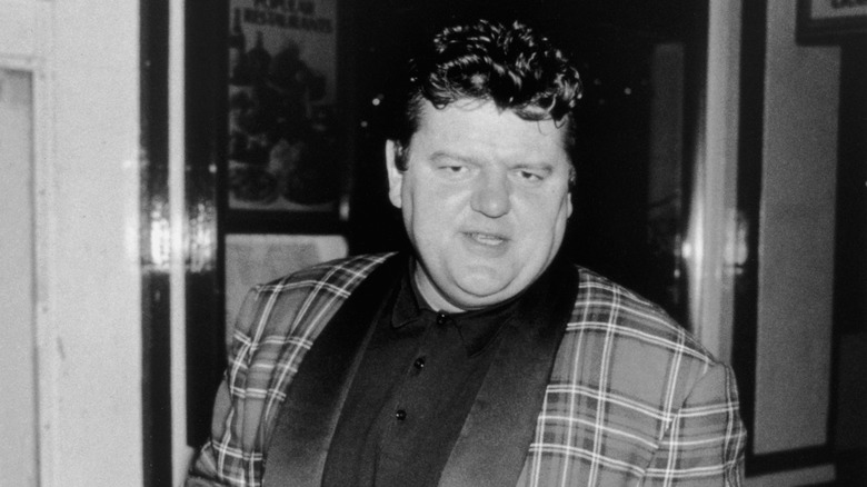 Young Robbie Coltrane in plaid coat 