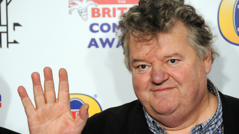 Robbie Coltrane waving to media 