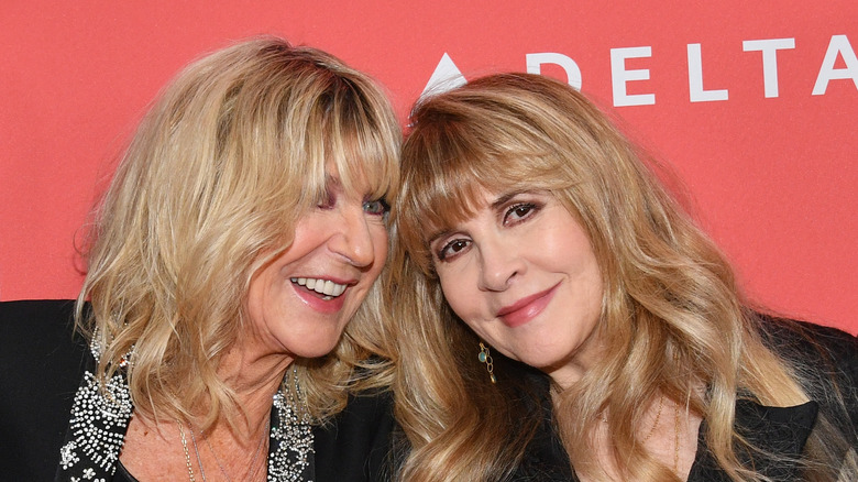 Christine McVie smiles at an event with Stevie Nicks