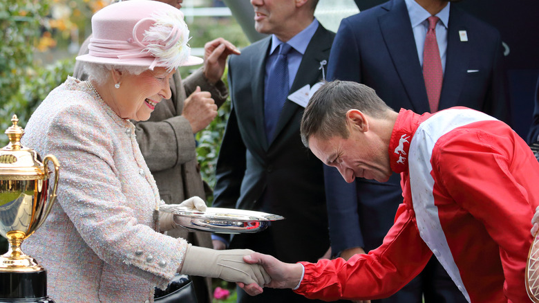 A jockey bows to the Queen