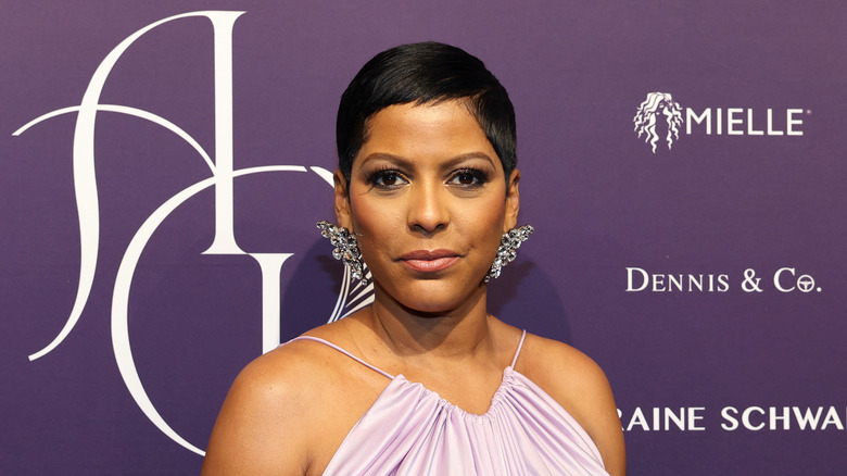 Tamron Hall posing on the red carpet in a purple dress