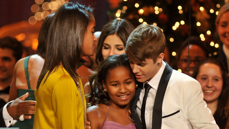 Justin Bieber hugging Sasha Obama with Malia Obama