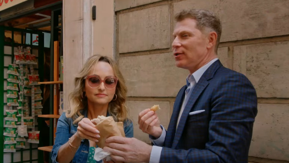 Bobby Flay and Giada De Laurentiis sharing a snack