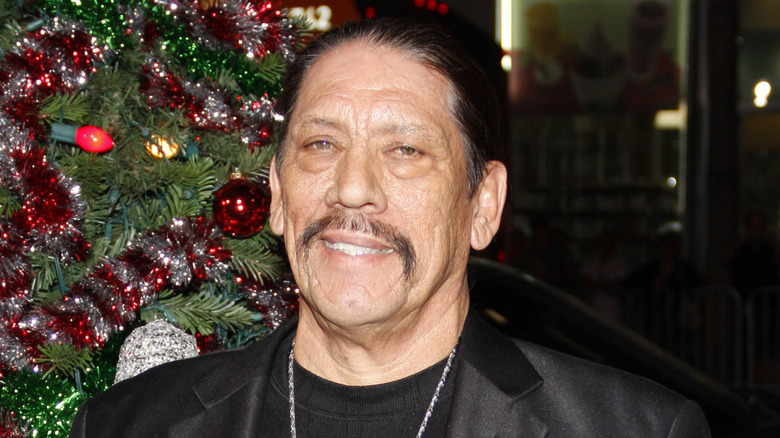 Danny Trejo by a Chrisrmas tree