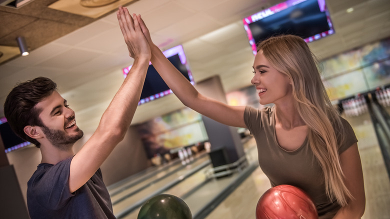 Couple bowling high fives
