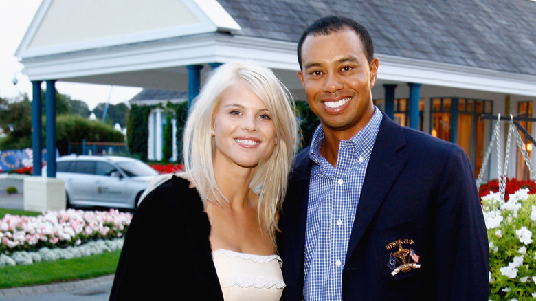 Tiger Woods and former wife Elin Nordegren stand arm in arm