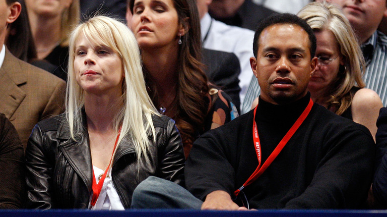 Tiger Woods and former wife Elin Nordegren sit in the stands of a game