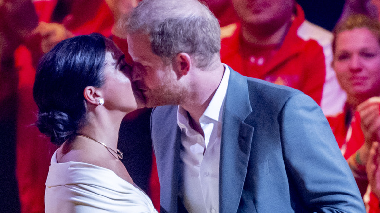 Meghan Markle and Prince Harry kissing on stage