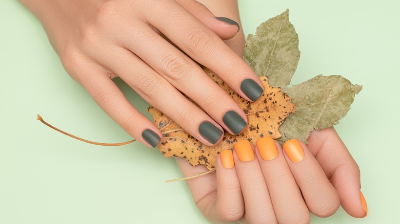 Green and orange manicured hands