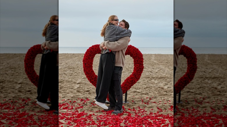 Abby Champion and Patrick Schwarzenegger hugging on beach