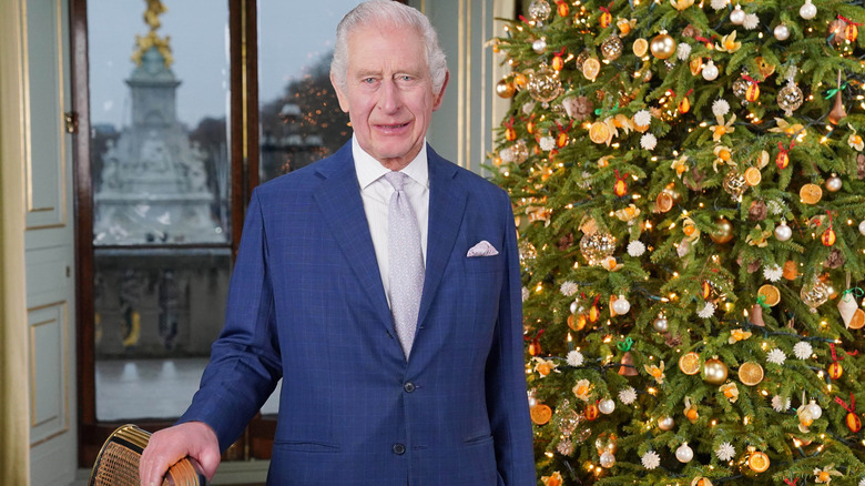 King Charles smiling with a Christmas tree in the background