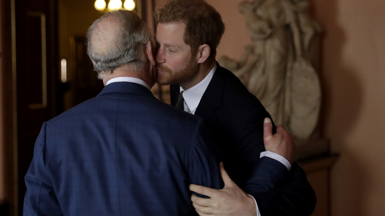 Prince Harry greeting King Charles with a kiss