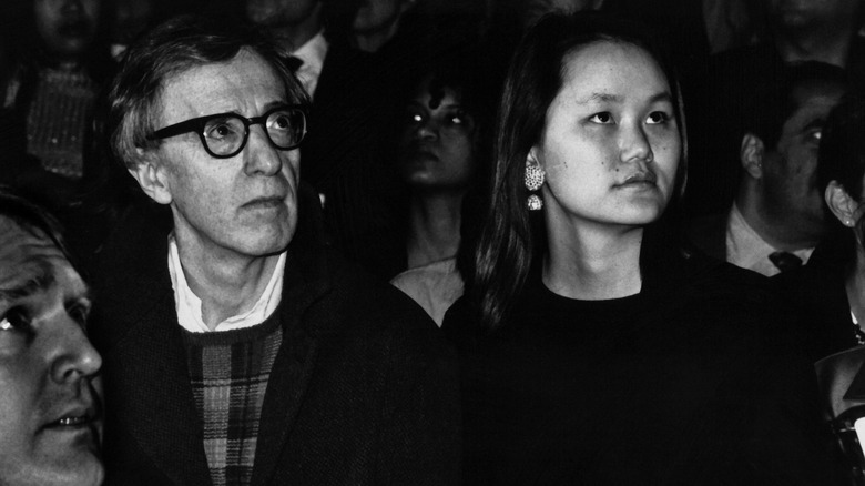 Woody Allen and Soon-Yi Previn looking up from a crowd