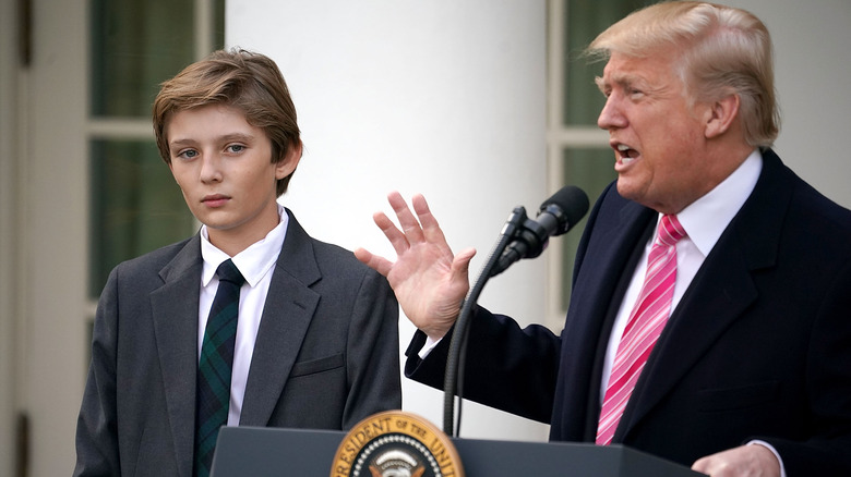 Barron Trump standing by Donald as he gives a speech