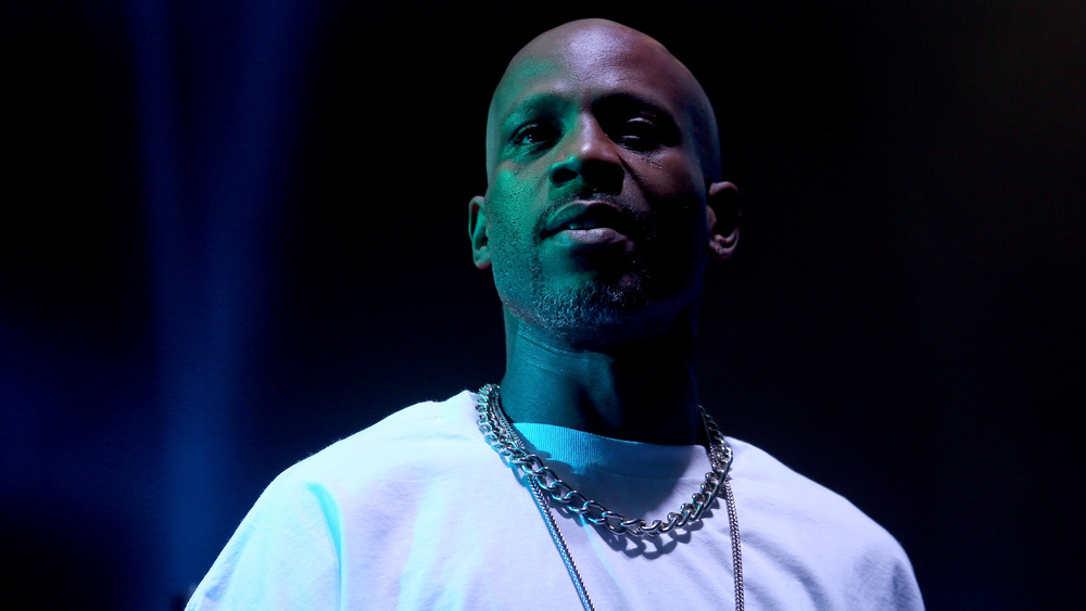 DMX performing on stage with large gold chain